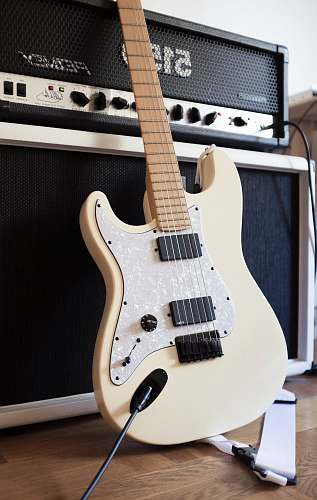 electric guitar white and black electric guitar beside black guitar amplifier guitar